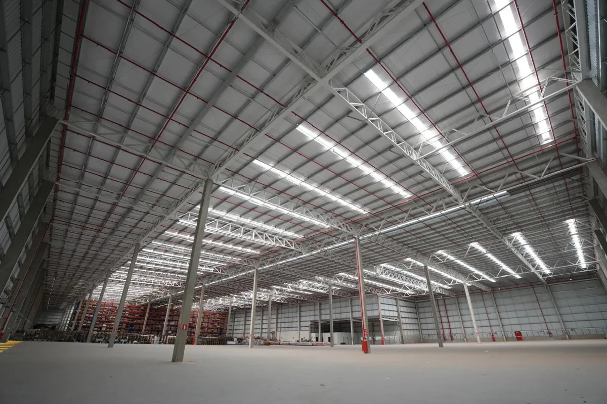 Interior of an empty warehouse with a high metal roof